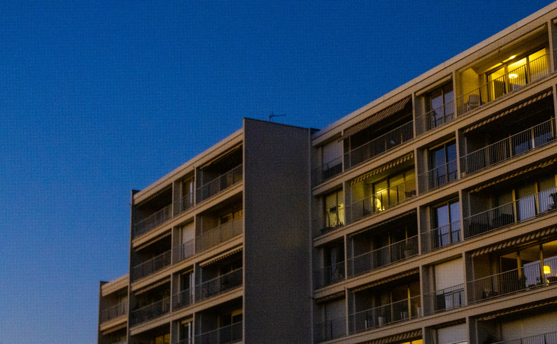 Multifamily apartment building at dusk with warm interior lighting